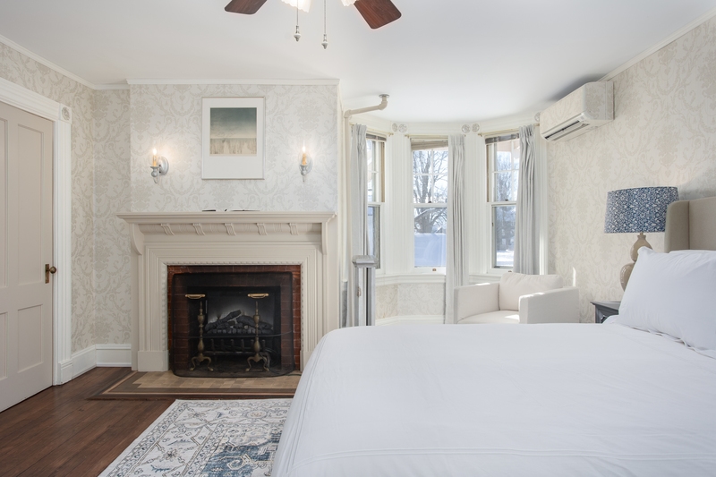 plush bed in a room featuring a fireplace