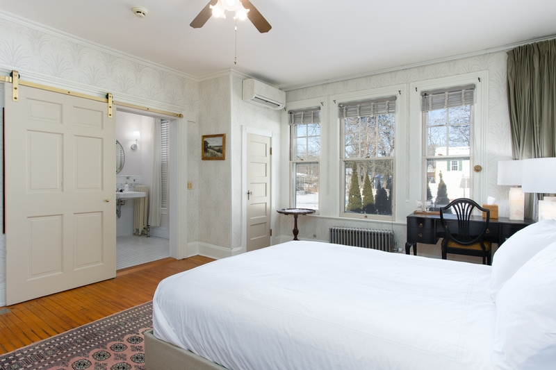 suite with plush bed, dresser, and flat screen tv