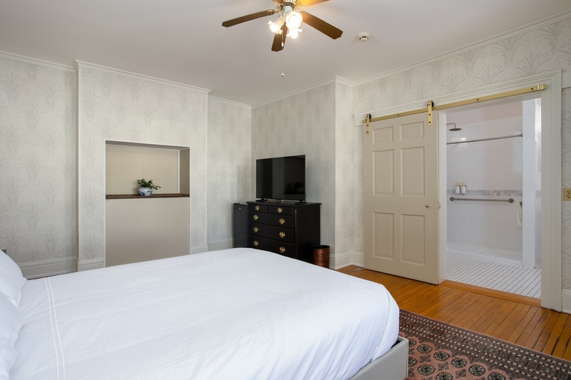 suite with plush bed, dresser, and flat screen tv
