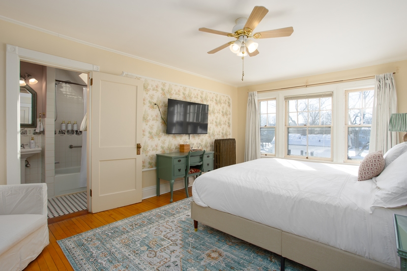 spacious room with king bed, plush bedding, large windows