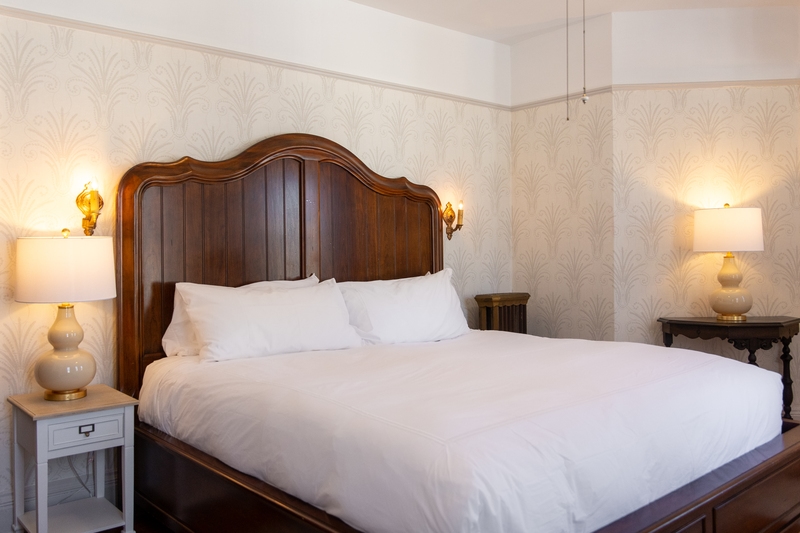 room featuring king bed, cozy rugs, desk with chair, and flat screen tv