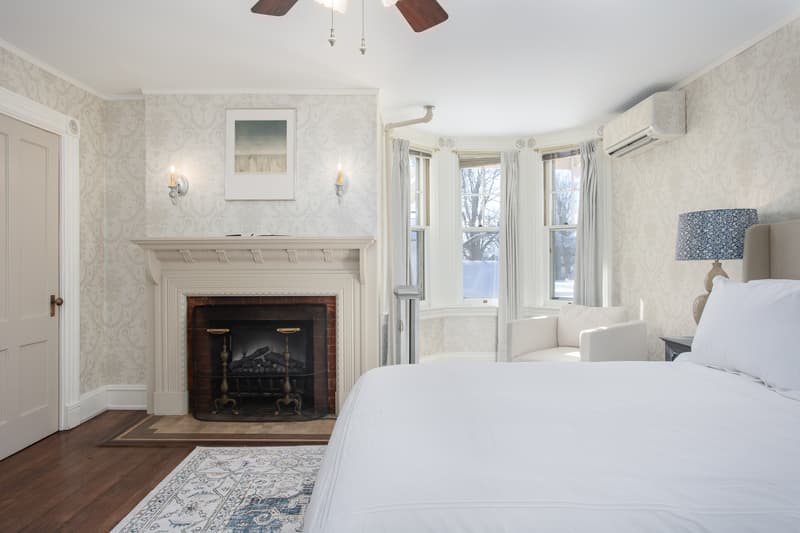 plush bed in a room featuring a fireplace