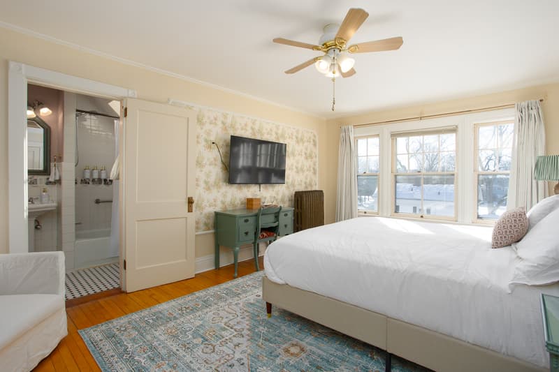 spacious room with king bed, plush bedding, large windows