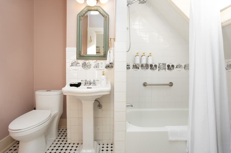 well-lit pink bathroom with mirror and toiletries