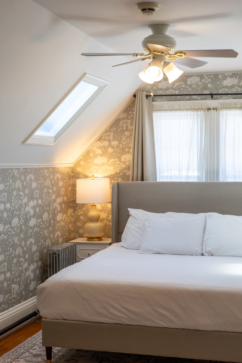 Cozy bedroom featuring a queen bed, bedside lamp, and skylight.
