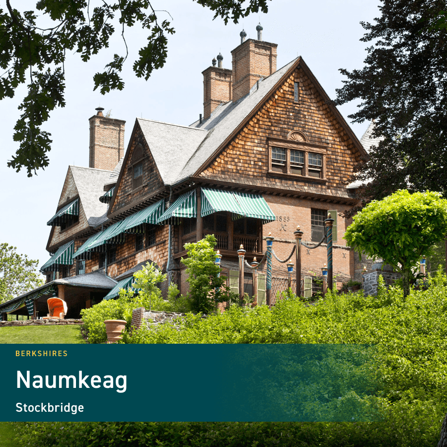 A historic shingle-style mansion surrounded by lush greenery in Stockbridge, Massachusetts.