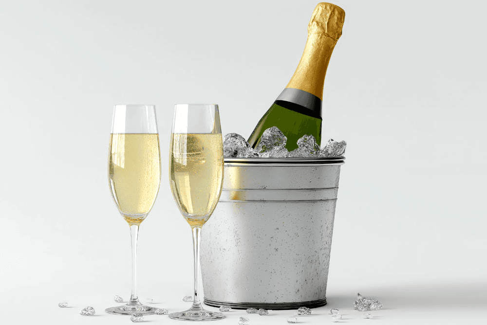 A bottle of champagne in an ice bucket with two fluted glasses.
