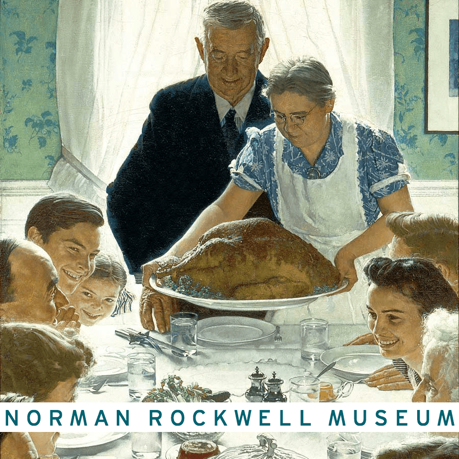 A woman serves a large turkey at a family gathering, with smiling faces around the table.